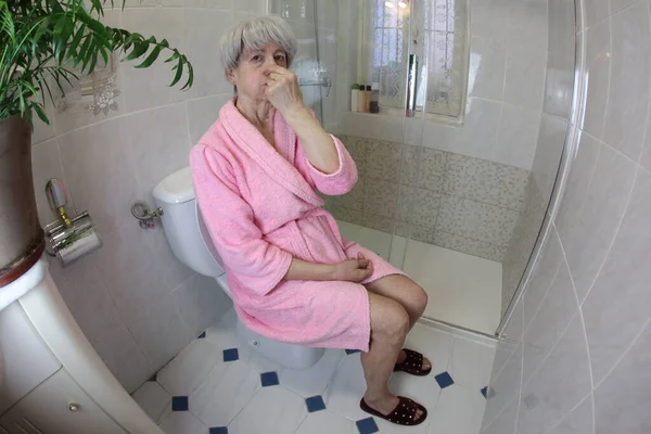 トイレに座りながら鼻を覆う先輩の広角撮影 — ストック写真