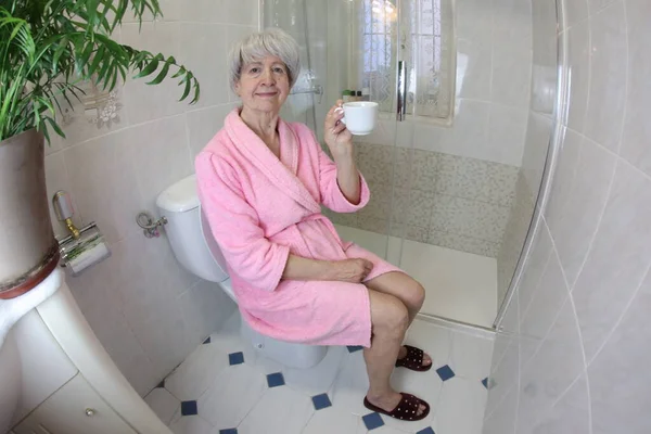 Bir Fincan Çayla Tuvalette Oturan Yaşlı Kadının Geniş Açılı Görüntüsü — Stok fotoğraf