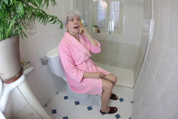 Широкоугольный Снимок Пожилой Женщины Разговаривающей Телефону Туалете — стоковое фото