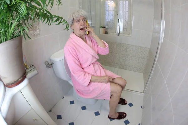 老年妇女在厕所用电话交谈的广角镜头 — 图库照片