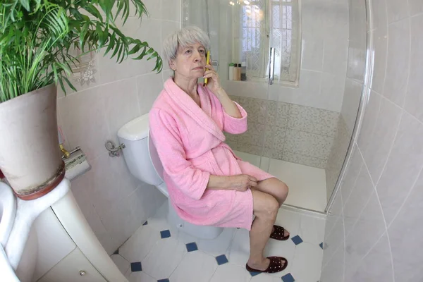 老年妇女在厕所用电话交谈的广角镜头 — 图库照片