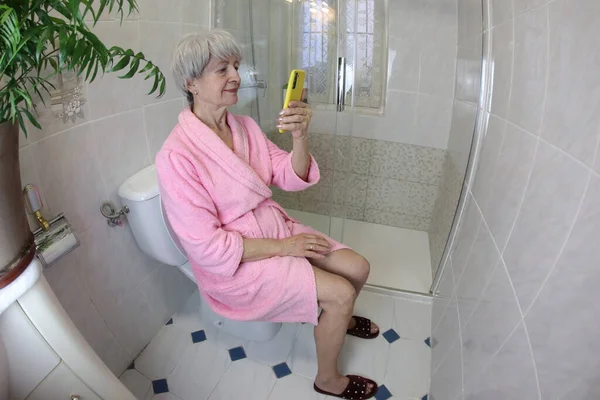 Широкоугольный Снимок Пожилой Женщины Помощью Смартфона Туалете — стоковое фото