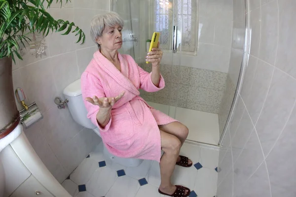 Ευρύ Πλάνο Γωνία Της Ηλικιωμένης Γυναίκας Χρησιμοποιώντας Smartphone Στην Τουαλέτα — Φωτογραφία Αρχείου