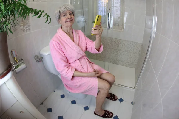 Szeroki Kąt Ujęcia Starszej Kobiety Pomocą Smartfona Toalecie — Zdjęcie stockowe