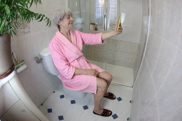 Tiro Ângulo Largo Mulher Sênior Tomando Selfie Enquanto Sentado Banheiro — Fotografia de Stock