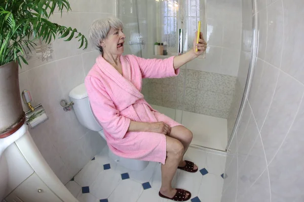 Tiro Ângulo Largo Mulher Sênior Tomando Selfie Enquanto Sentado Banheiro — Fotografia de Stock