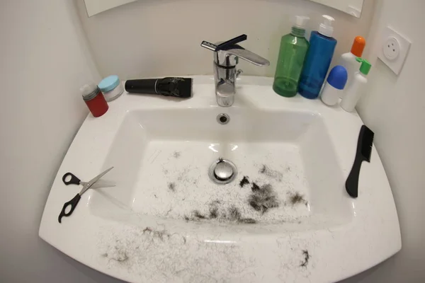 Stock image close-up shot of haircut and shaving equipment on sink in bathroom