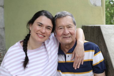 Baba ve genç kızının sokakta çekilmiş yakın plan portresi.