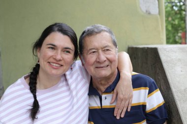 Baba ve genç kızının sokakta çekilmiş yakın plan portresi.