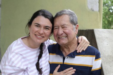 Baba ve genç kızının sokakta çekilmiş yakın plan portresi.