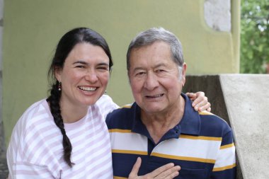 Baba ve genç kızının sokakta çekilmiş yakın plan portresi.