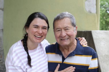 Baba ve genç kızının sokakta çekilmiş yakın plan portresi.