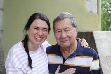 Baba ve genç kızının sokakta çekilmiş yakın plan portresi.
