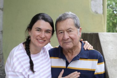 Baba ve genç kızının sokakta çekilmiş yakın plan portresi.