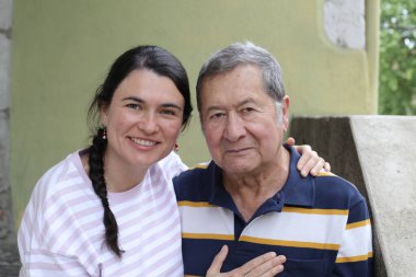 Baba ve genç kızının sokakta çekilmiş yakın plan portresi.