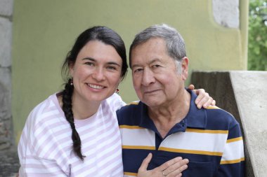 Baba ve genç kızının sokakta çekilmiş yakın plan portresi.