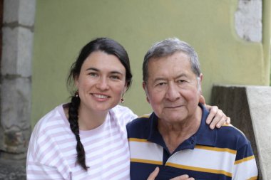 Baba ve genç kızının sokakta çekilmiş yakın plan portresi.