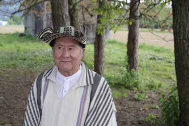 Doğada geleneksel Kolombiya kıyafetleri içinde yakışıklı bir adamın portresi.