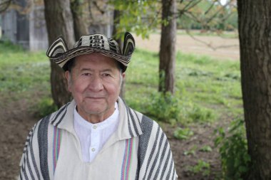 Doğada geleneksel Kolombiya kıyafetleri içinde yakışıklı bir adamın portresi.