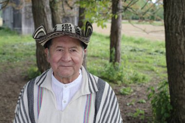 Doğada geleneksel Kolombiya kıyafetleri içinde yakışıklı bir adamın portresi.