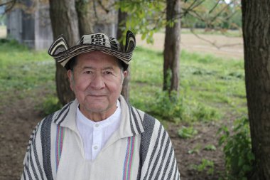 Doğada geleneksel Kolombiya kıyafetleri içinde yakışıklı bir adamın portresi.