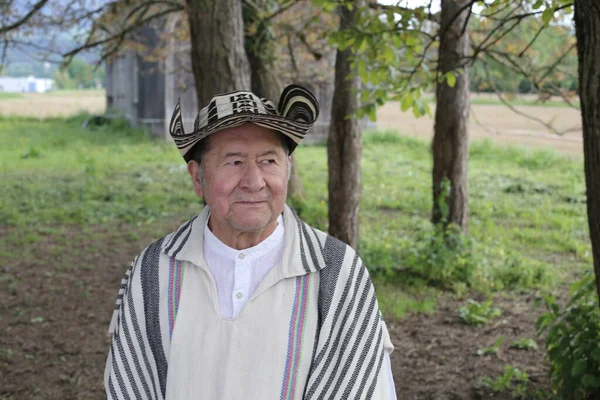 stock image portrait of handsome senior man in traditional Colombian clothes on nature