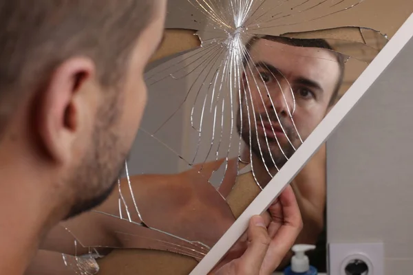浴室の粉々になった鏡の前にいる若い男の肖像画 — ストック写真