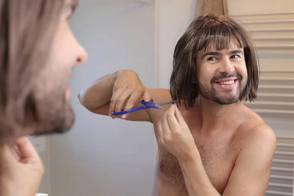 浴室の鏡の前で散髪をしている若い男の肖像画 — ストック写真