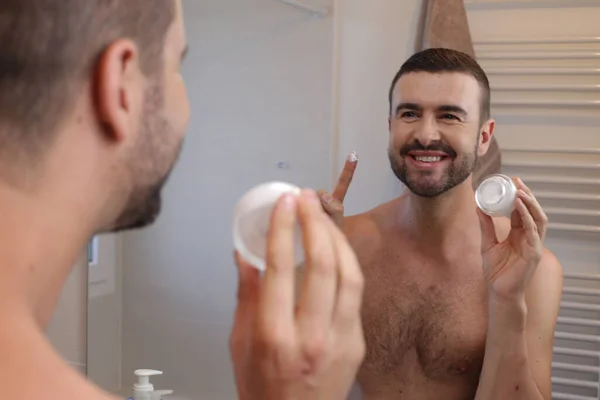 Portrait Young Man Jar Moisturizing Cream Front Mirror Bathroom — Stock Photo, Image