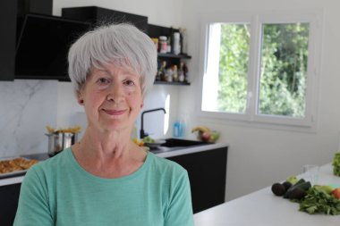 Mutfaktaki olgun kadının yakın plan portresi.