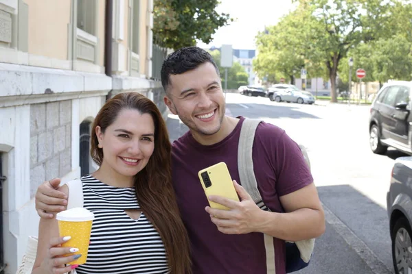 若い幸せな夫婦の肖像画と紙のコーヒーとスマートフォンのカップを一緒に — ストック写真