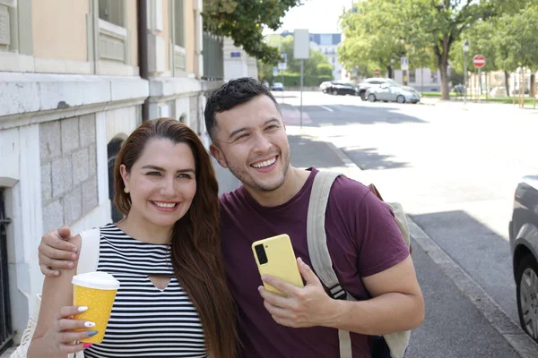 若い幸せな夫婦の肖像画と紙のコーヒーとスマートフォンのカップを一緒に — ストック写真