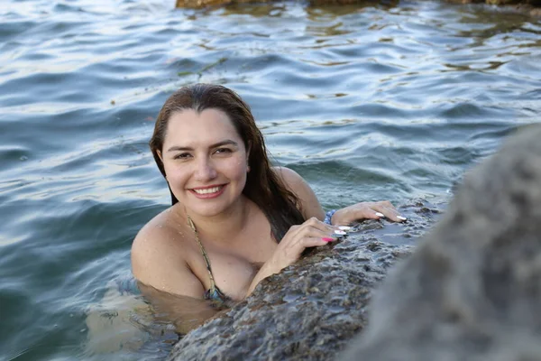 身穿比基尼的年轻漂亮女子的特写 在岩石海岸的水里摆姿势 — 图库照片