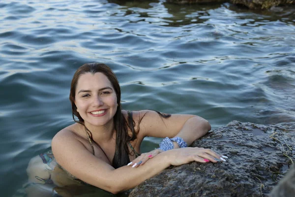 身穿比基尼的年轻漂亮女子的特写 在岩石海岸的水里摆姿势 — 图库照片
