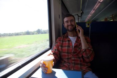 Trenle seyahat eden yakışıklı genç adamın portresi.