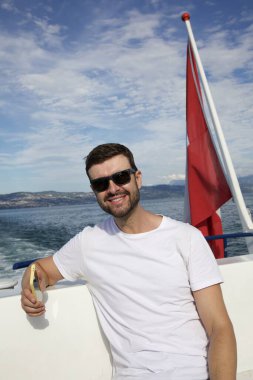 Tatilde motorlu tekneye binen yakışıklı genç adamın portresi.