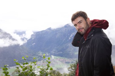 Dağlarda gezen yakışıklı genç adamın portresi.