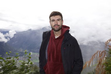 Dağlarda gezen yakışıklı genç adamın portresi.