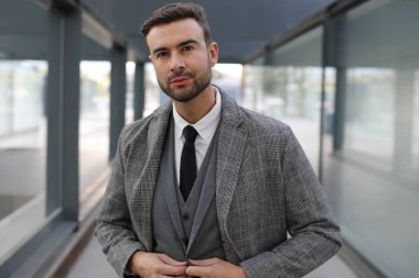 Şehir caddesinde gri takım elbiseli yakışıklı bir gencin portresi.