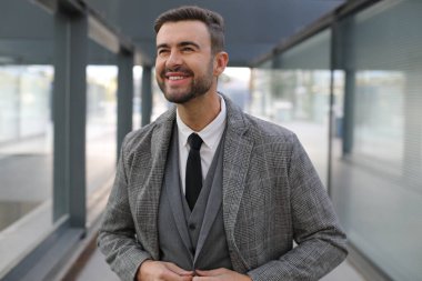 Şehir caddesinde gri takım elbiseli yakışıklı bir gencin portresi.