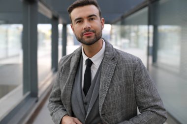 Şehir caddesinde gri takım elbiseli yakışıklı bir gencin portresi.