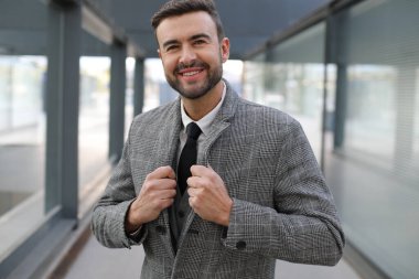 Şehir caddesinde gri takım elbiseli yakışıklı bir gencin portresi.