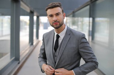 Şehir caddesinde gri takım elbiseli yakışıklı bir gencin portresi.