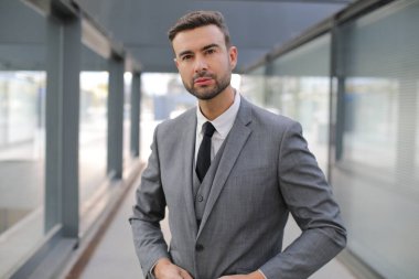 Şehir caddesinde gri takım elbiseli yakışıklı bir gencin portresi.