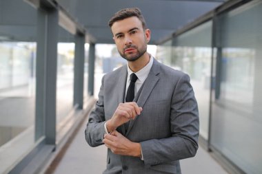 Şehir caddesinde gri takım elbiseli yakışıklı bir gencin portresi.