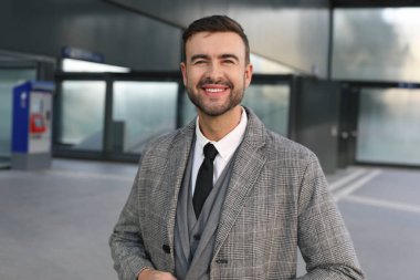 Şehir caddesinde gri takım elbiseli yakışıklı bir gencin portresi.