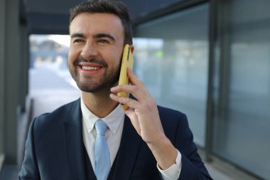 Şehir caddesinde akıllı telefonlu yakışıklı iş adamının portresi.