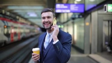 Tren istasyonundaki yakışıklı genç iş adamının yakın plan portre görüntüleri.