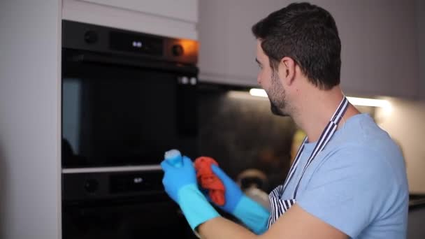 自宅のキッチンで物資を掃除するハンサムな若者のクローズアップ映像 — ストック動画