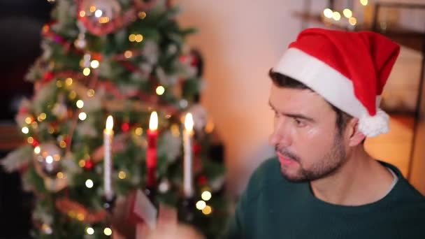 クリスマスを祝う空の財布を持つ幸せなハンサムな若者のクローズアップ映像 — ストック動画